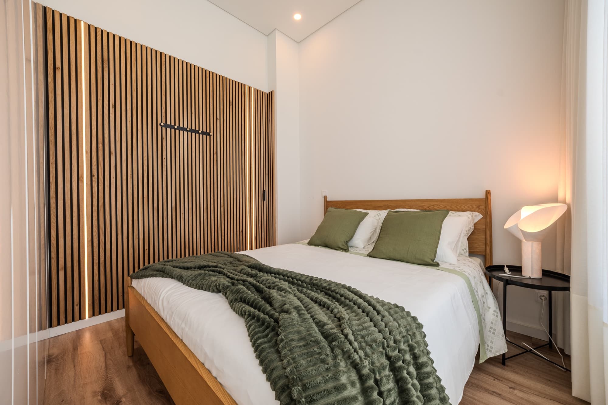 Quarto com guarda-fatos embutido em painel ripado
