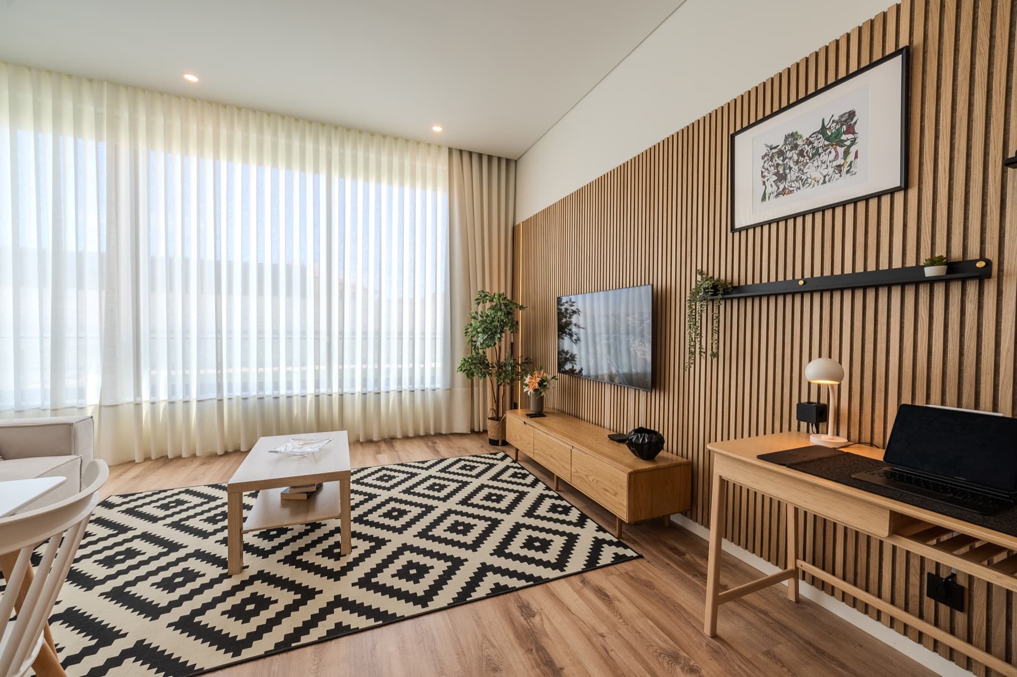 Sala com painel ripado de madeira e TV